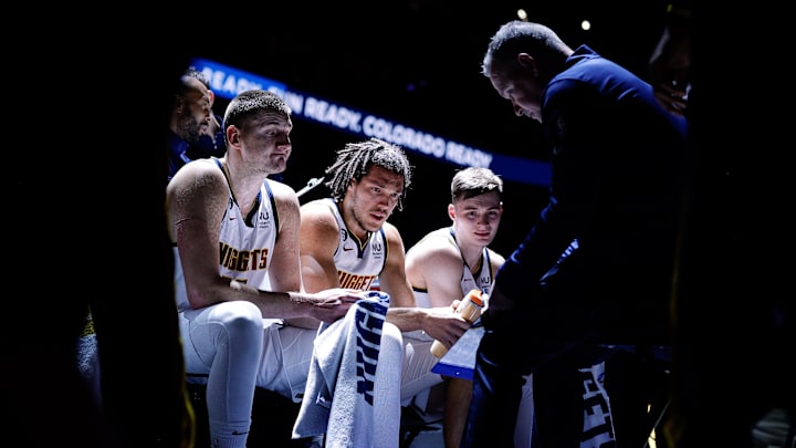 Denver Nuggets center Nikola Jokic (15) and forward Aaron Gordon (50) and guard Christian Braun (0) look on as head coach Michael Malone talks during a timeout in the first quarter against the Memphis Grizzlies at Ball Arena. 