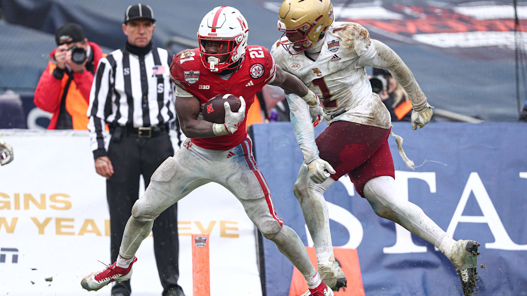 Dec 28, 2024; Bronx, NY, USA; Nebraska Cornhuskers running back Emmett Johnson (21) scores a touchdown as Boston College Eagles linebacker Daveon Crouch (1) defends during the second half at Yankee Stadium. Mandatory Credit: Vincent Carchietta-Imagn Images