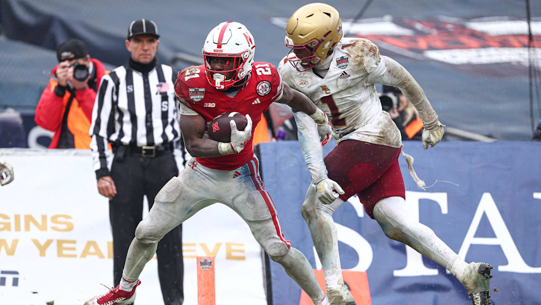 Dec 28, 2024; Bronx, NY, USA; Nebraska Cornhuskers running back Emmett Johnson (21) scores a touchdown as Boston College Eagles linebacker Daveon Crouch (1) defends during the second half at Yankee Stadium. Mandatory Credit: Vincent Carchietta-Imagn Images