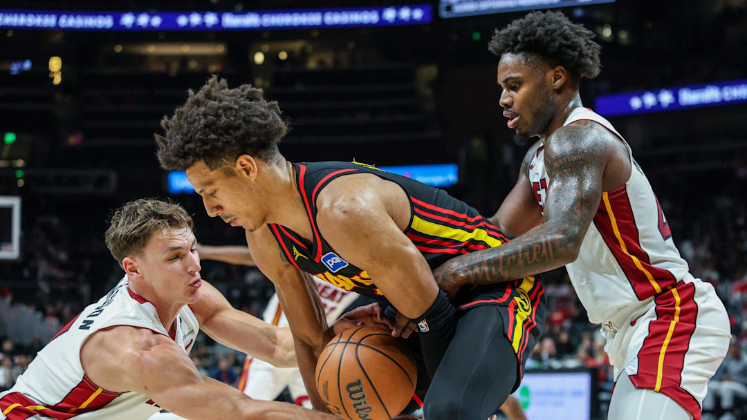 Dec 26, 2025; Atlanta, Georgia, USA; Atlanta Hawks forward Jalen Johnson (1) fights for the ball against Miami Heat guard Pelle Larsson (9) and Miami Heat guard Davion Mitchell (45) during the fourth quarter at State Farm Arena. Mandatory Credit: Jordan Godfree-Imagn Images