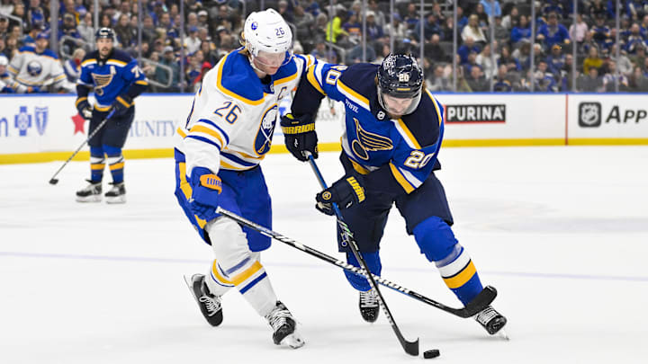 Dec 29, 2024; St. Louis, Missouri, USA;  St. Louis Blues left wing Brandon Saad (20) controls the puck as Buffalo Sabres defenseman Rasmus Dahlin (26) defends during the second period at Enterprise Center. Mandatory Credit: Jeff Curry-Imagn Images