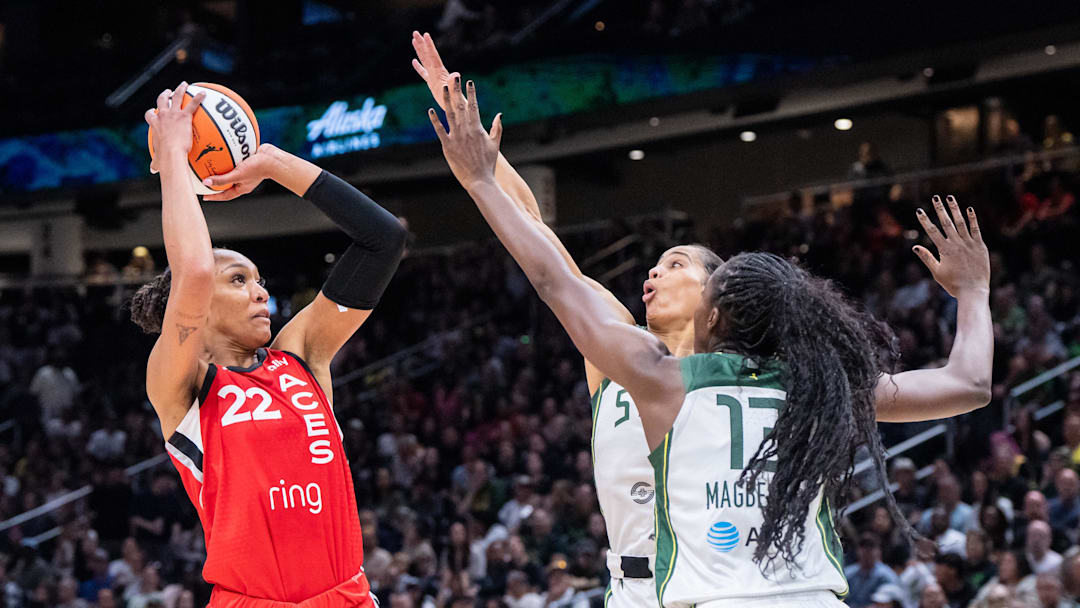 May 25, 2025; Seattle, Washington, USA;  Las Vegas Aces center A'ja Wilson (22) shoots the ball against Seattle Storm forward Gabby Williams (5) and forward Ezi Magbegor (13) during the first half at Climate Pledge Arena. Mandatory Credit: Stephen Brashear-Imagn Images