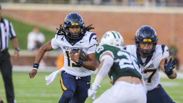 Sep 6, 2025; Athens, Ohio, USA; West Virginia Mountaineers quarterback Jaylen Henderson (13) runs the ball during the fourth quarter against the Ohio Bobcats at Peden Stadium. Mandatory Credit: Ben Queen-Imagn Images