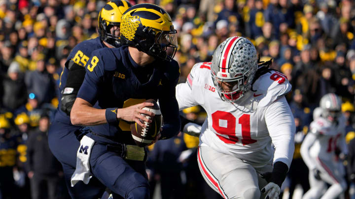 Nov. 25, 2023; Ann Arbor, Mi., USA;
Michigan Wolverines quarterback J.J. McCarthy (9) is pursued by Ohio State Buckeyes defensive tackle Tyleik Williams (91) during the first half of Saturday's NCAA Division I football game at Michigan Stadium.