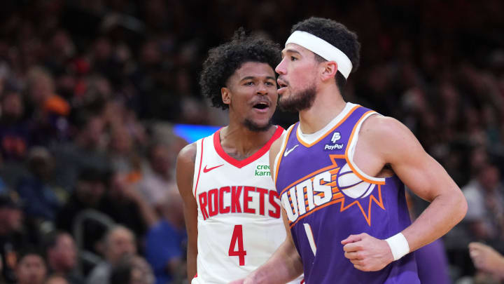 Mar 2, 2024; Phoenix, Arizona, USA; Houston Rockets guard Jalen Green (4) reacts in front of Phoenix Suns guard Devin Booker (1) during the second half at Footprint Center. Mandatory Credit: Joe Camporeale-USA TODAY Sports