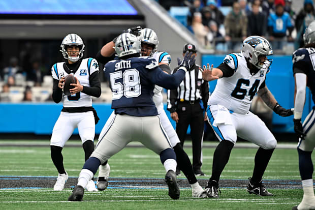 Carolina Panthers quarterback Bryce Young looks to pass as Dallas Cowboys defensive tackle Mazi Smith. 