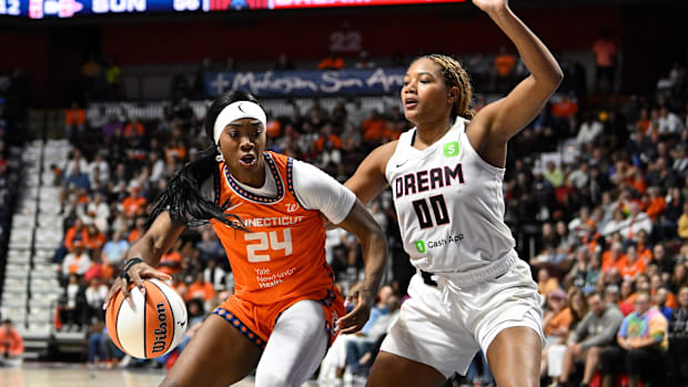 Connecticut Sun forward Aneesah Morrow drives to the hoop, wearing an orange jersey with black borders. 