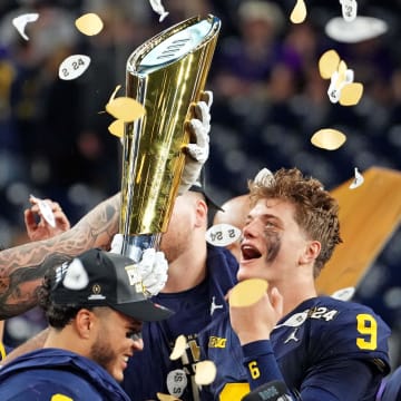 Jan 8, 2024; Houston, TX, USA; Michigan Wolverines offensive lineman Trevor Keegan (77) and quarterback J.J. McCarthy (9) celebrate with CFP National Championship trophy after the Washington Huskies in the 2024 College Football Playoff national championship game at NRG Stadium. Mandatory Credit: Kirby Lee-USA TODAY Sports