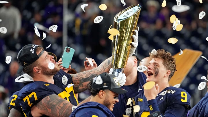 Jan 8, 2024; Houston, TX, USA; Michigan Wolverines offensive lineman Trevor Keegan (77) and quarterback J.J. McCarthy (9) celebrate with CFP National Championship trophy after the Washington Huskies in the 2024 College Football Playoff national championship game at NRG Stadium. Mandatory Credit: Kirby Lee-USA TODAY Sports