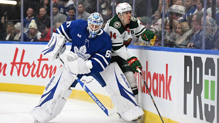 Jan 29, 2025; Toronto, Ontario, CAN;  Minnesota Wild forward Joel Eriksson Ek (14) collides with Toronto Maple Leafs goalie Joseph Woll (60) as they pursue a loose puck in the second period at Scotiabank Arena. Mandatory Credit: Dan Hamilton-Imagn Images