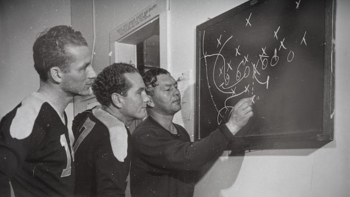Don Hutson and left halfback Cecil Isbell look on as Curly Lambeau diagrams a play. Before he abruptly retired following the 1942 season, Isbell (center) was on his way to becoming one of the greatest passers of pro football's first 50 years. 