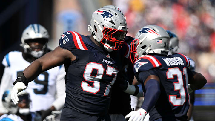 Sep 28, 2025; Foxborough, Massachusetts, USA; New England Patriots defensive end Milton Williams (97) and safety Craig Woodson (31) react after making at tackle against the Carolina Panthers during the first half at Gillette Stadium. Mandatory Credit: Brian Fluharty-Imagn Images
