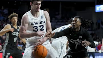 Dec 14, 2024; Cincinnati, Ohio, USA; Cincinnati Bearcats guard Day Day Thomas (1) pokes the ball away from Xavier Musketeers forward Zach Freemantle (32) in the second half at Fifth Third Arena. Mandatory Credit: Aaron Doster-Imagn Images