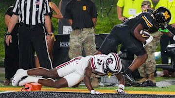 Sep 20, 2025; Columbia, Missouri, USA; Missouri Tigers running back Jamal Roberts (20) scores a touchdown as South Carolina Gamecocks defensive back David Bucey (13) attempts the tackle during the second half of the game at Faurot Field at Memorial Stadium. Mandatory Credit: Denny Medley-Imagn Images