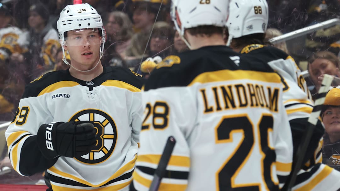 Apr 13, 2025; Pittsburgh, Pennsylvania, USA;  Boston Bruins center Morgan Geekie (39) celebrates with center Elias Lindholm (28) and right wing David Pastrnak (88)  after scoring a goal against the Pittsburgh Penguins during the second period at PPG Paints Arena. Mandatory Credit: Charles LeClaire-Imagn Images