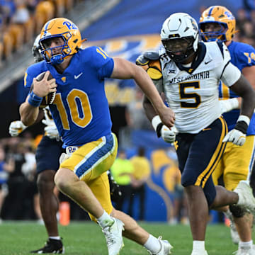 Sep 14, 2024; Pittsburgh, Pennsylvania, USA; Pittsburgh Panthers quarterback Eli Holstein (10) runs against West Virginia Mountaineers defensive lineman Sean Martin (5) during the fourth quarter at Acrisure Stadium. Mandatory Credit: Barry Reeger-Image Images