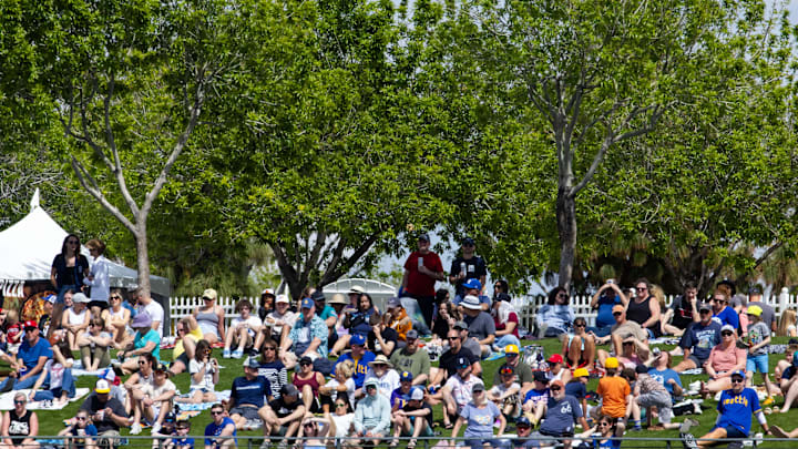 Mar 18, 2024; Surprise, Arizona, USA; Overall view of fans sitting in the outfield grass lawn during the Texas Rangers against the Seattle Mariners during a spring training baseball game at Surprise Stadium. Mandatory Credit: Mark J. Rebilas-Imagn Images
