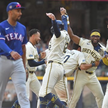 Jun 26, 2024; Milwaukee, Wisconsin, USA; Milwaukee Brewers second base Andruw Monasterio (14) celebrates with teammates after driving in the winning run against the Texas Rangers in the tenth inning at American Family Field. Mandatory Credit: Michael McLoone-USA TODAY Sports