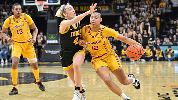 Feb 2, 2025; Iowa City, Iowa, USA; USC Trojans guard JuJu Watkins (12) drives with the ball as Iowa Hawkeyes guard Kylie Feue