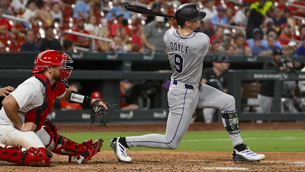 Doyle in an all grey uniform hits a single in white cleats with a black helme