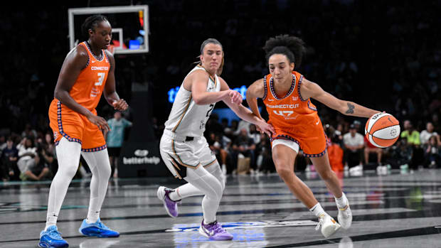Lacan driving the paint with an orange jersey and white shoes against the Liber