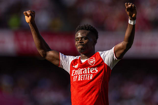 Bukayo Saka with arms aloft.
