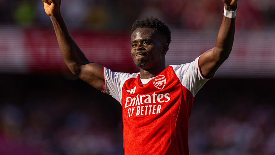 Bukayo Saka with arms aloft.