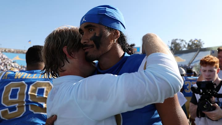  UCLA Bruins quarterback Nico Iamaleava (9,right) hugs new offensive coordinator Jerry Neuheisel after defeating the Penn State Nittany Lions 42-37 at Rose Bowl. Mandatory Credit: Kiyoshi Mio-Imagn Images