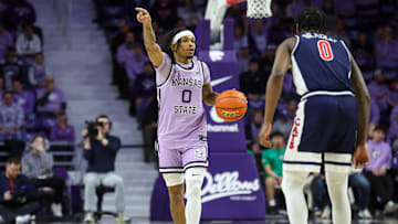 Feb 11, 2025; Manhattan, Kansas, USA; Kansas State Wildcats guard Dug McDaniel (0) brings the ball up court against Arizona Wildcats guard Jaden Bradley (0) during the first half at Bramlage Coliseum. Mandatory Credit: Scott Sewell-Imagn Images