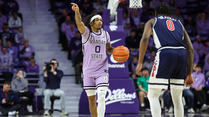 Feb 11, 2025; Manhattan, Kansas, USA; Kansas State Wildcats guard Dug McDaniel (0) brings the ball up court against Arizona Wildcats guard Jaden Bradley (0) during the first half at Bramlage Coliseum. Mandatory Credit: Scott Sewell-Imagn Images