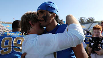 Oct 4, 2025; Pasadena, California, USA;  UCLA Bruins quarterback Nico Iamaleava (9,right) hugs new offensive coordinator Jerry Neuheisel after defeating the Penn State Nittany Lions 42-37 at Rose Bowl. Mandatory Credit: Kiyoshi Mio-Imagn Images