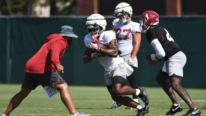 The Alabama Crimson Tide football team works out Sunday morning in practice as they prepare for the 2024 season. Alabama running back Justice Haynes (22) makes cut around Alabama running backs coach Robert Gillespie.