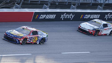 Aug 31, 2025; Darlington, South Carolina, USA; NASCAR Cup Series driver Chase Briscoe (19) leads driver Denny Hamlin (11) out of turn four during the Cookouts Southern 500 at Darlington Raceway.