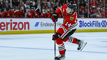 Mar 30, 2025; Chicago, Illinois, USA;  Chicago Blackhawks defenseman Kevin Korchinski (14) shoots against the Utah Hockey Club during the first period at United Center. Mandatory Credit: Matt Marton-Imagn Images