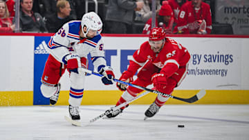Apr 5, 2024; Detroit, Michigan, USA; New York Rangers defenseman Erik Gustafsson (56) and Detroit Red Wings right wing Christian Fischer (36) battle for the puck during the second period at Little Caesars Arena. Mandatory Credit: Tim Fuller-Imagn Images