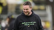 Oct 25, 2025; Eugene, Oregon, USA; Oregon Ducks head coach Dan Lanning encourages players during warm ups before a game against the Wisconsin Badgers at Autzen Stadium. The Ducks are wearing uniforms celebrating the Grateful Dead. Mandatory Credit: Troy Wayrynen-Imagn Images