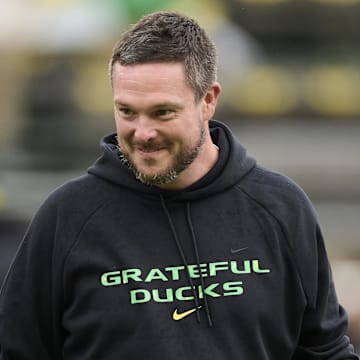 Oct 25, 2025; Eugene, Oregon, USA; Oregon Ducks head coach Dan Lanning encourages players during warm ups before a game against the Wisconsin Badgers at Autzen Stadium. The Ducks are wearing uniforms celebrating the Grateful Dead. Mandatory Credit: Troy Wayrynen-Imagn Images