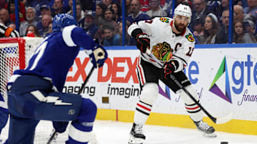 Jan 28, 2025; Tampa, Florida, USA; Chicago Blackhawks left wing Nick Foligno (17) passes the puck as Tampa Bay Lightning defenseman Victor Hedman (77) defends during the second period at Amalie Arena. Mandatory Credit: Kim Klement Neitzel-Imagn Images