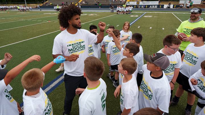 Oregon quarterback Dante Moore huddles a group of kids during a youth football camp at Marist Catholic High School on June 20, 2026, in Eugene, Oregon.