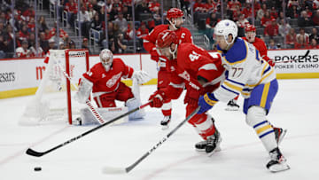 Apr 7, 2024; Detroit, Michigan, USA; Detroit Red Wings defenseman Shayne Gostisbehere (41) and Buffalo Sabres right wing JJ Peterka (77) battle for the puck in the first period at Little Caesars Arena. Mandatory Credit: Rick Osentoski-Imagn Images
