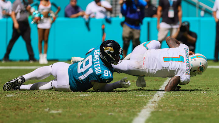 Sep 8, 2024; Miami Gardens, Florida, USA; Miami Dolphins quarterback Tua Tagovailoa (1) is sacked by Jacksonville Jaguars defensive end Arik Armstead (91) during the third quarter at Hard Rock Stadium. Mandatory Credit: Sam Navarro-Imagn Images