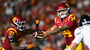 Sep 7, 2024; Los Angeles, California, USA; USC Trojans quarterback Jayden Maiava (14) hands off the ball to USC Trojans running back Bryan Jackson (21) against the Utah State Aggies during the third quarter at United Airlines Field at Los Angeles Memorial Coliseum. Mandatory Credit: Jonathan Hui-Imagn Images