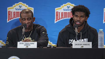 Dec 28, 2024; San Antonio, TX, USA; Colorado Buffaloes head coach Deion Sanders and quarterback Shedeur Sanders (2) talk with the media after the game against the Brigham Young Cougars at Alamodome. Mandatory Credit: Troy Taormina-Imagn Images