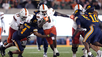 Oct 5, 2024; Berkeley, California, USA; Miami Hurricanes running back Mark Fletcher Jr. (center) carries the ball against California Golden Bears defensive back Miles Williams (center left) during the second quarter at California Memorial Stadium. Mandatory Credit: Darren Yamashita-Imagn Images