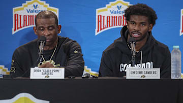 Dec 28, 2024; San Antonio, TX, USA; Colorado Buffaloes head coach Deion Sanders and quarterback Shedeur Sanders (2) talk with the media after the game against the Brigham Young Cougars at Alamodome. Mandatory Credit: Troy Taormina-Imagn Images