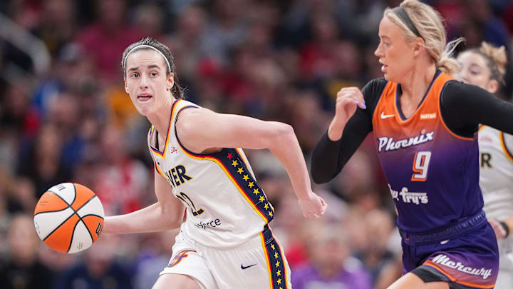 Indiana Fever guard Caitlin Clark (22) rushes up the court against Phoenix Mercury guard Sophie Cunningham (9) on Friday, July 12, 2024, during the game at Gainbridge Fieldhouse in Indianapolis.