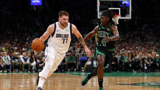 Dallas Mavericks guard Luka Doncic dribbles the ball against Boston Celtics guard Jrue Holiday during the first quarter in game two of the 2024 NBA Finals at TD Garden.