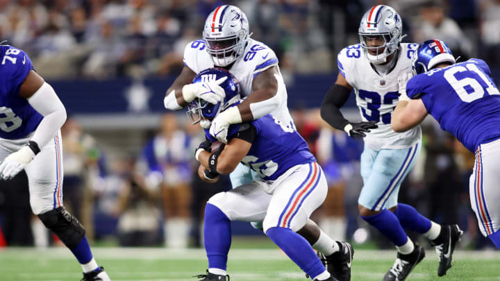 Nov 12, 2023; Arlington, Texas, USA; Dallas Cowboys defensive tackle Neville Gallimore (96) tackles New York Giants running back Saquon Barkley (26) in the second quarter at AT&T Stadium.  