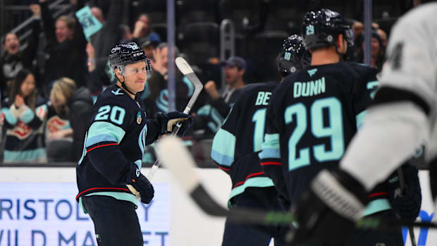 Hockey players in blue uniforms celebrate a goal score