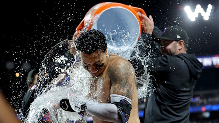 Sep 6, 2024; New York City, New York, USA; New York Mets third baseman Mark Vientos (27) doused with gatorade by right fielder Tyrone Taylor (15) and starting pitcher David Peterson (23) following his tenth inning walkoff two run home run against the Cincinnati Reds at Citi Field. Mandatory Credit: Brad Penner-Imagn Images